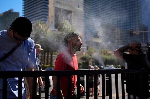 People cool off in misters along the Las Vegas Strip, Sunday, July 7, 2024, in Las Vegas.
