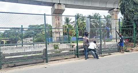 Workers install an iron mesh around the stormwater drain 
near Jnanabharati Junction on Sunday 