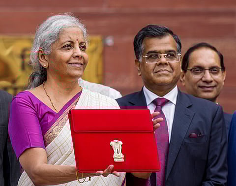 Union Finance Minister Nirmala Sitharaman along with Finance Secretary T V Somanathan displays a red pouch carrying the Budget documents outside the Finance Ministry in North Block before leaving for the Parliament where she will table the Union Budget 2024-25, in New Delhi, Tuesday, July 23, 2024. 
