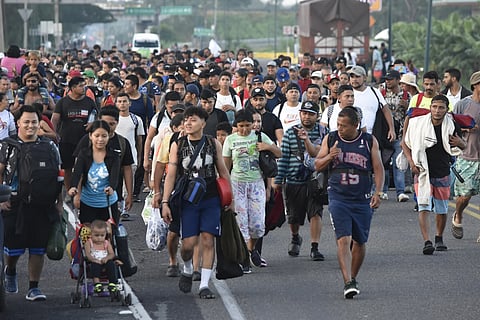 Migrants walk along the highway through Suchiate, Chiapas state in Southern Mexico, Sunday, July 21, 2024, during their journey north toward the US border.
