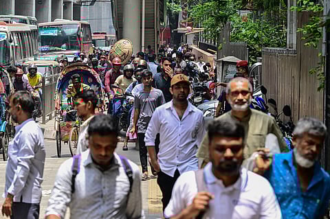 Commuters are seen moving along a road in Dhaka on July 24, 2024, after authorities eased a curfew imposed to contain deadly clashes sparked by student protests.