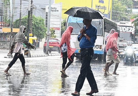 City residents take cover from the sudden rain that lashed  Statue Junction in Thiruvananthapuram (Representative Image)