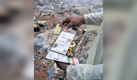 Rescue workers inspect documents of an individual trapped in the landslide.