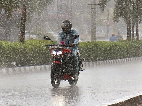 A two-wheeler rider braves the rain in Bhubaneswar.