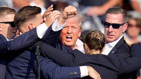 Republican presidential candidate and former President Donald Trump is helped off the stage by US Secret Service agents at a campaign event in Butler, Pennsylvania.