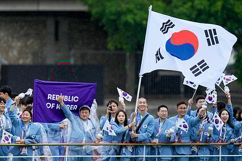 South Korea's Kim Seo-yeong and Woo Sang-hyeok travel on a boat with teammates along the Seine River in Paris, France, during the opening ceremony of the 2024 Summer Olympics on Friday.