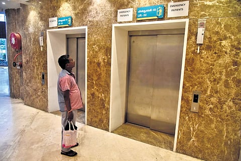 An attendant waiting near the main portico lift at the Kalaignar Centenary Super Specialty Hospital at Guindy in Chennai