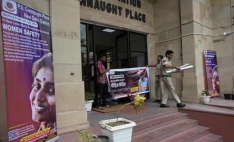 Police personnel put up posters with information on the new criminal laws to create awareness among the public at Connaught Place Police Station in Delhi (Photo | Shekhar Yadav)