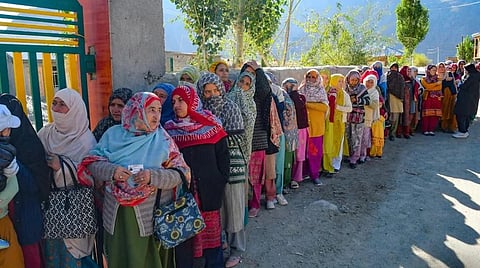 People wait to cast their vote in a queue outside a polling station in J&K. 