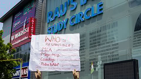 A placard held by a student during a protest after three civil services aspirants died due to drowning at a coaching centre in Old Rajinder Nagar area, in New Delhi.