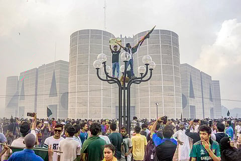 Protesters climb a public monument as they celebrate after getting the news of Prime Minister Sheikh Hasina's resignation, in Dhaka, Bangladesh, Monday, Aug. 5, 2024.