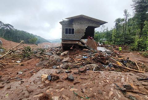 A damaged house stands amid the debris at the debris at the landslide- hit Mundakkai in Wayanad. 