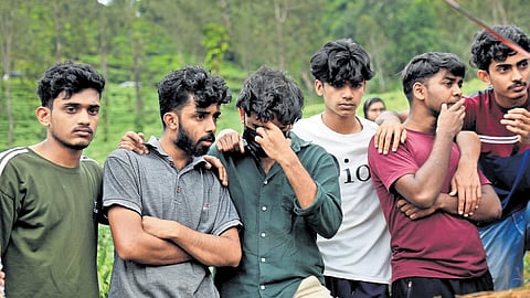 A group of youths turns emotional during the mass burial of the unidentified bodies of landslide victims at Puthumala tea estate