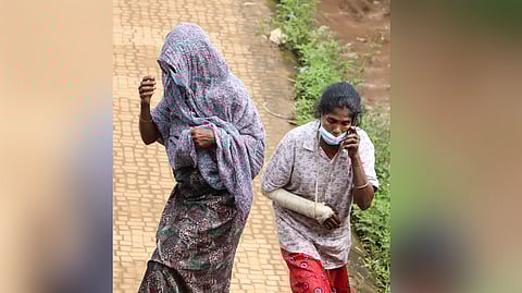 Women walk to the temporary relief camp at GHSS Meppadi in Wayanad where hundreds of victims of the landslides have been lodged.