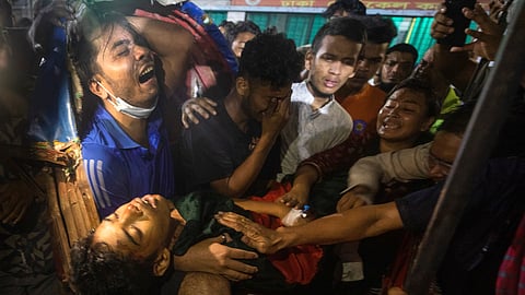 People cry as the dead body of a man, who was killed during the anti-government protests in Bangladesh, is brought to a hospital in Dhaka.
