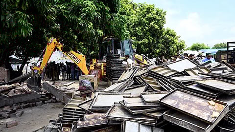 A bulldozer being used to demolish the bakery of Moid Khan who is accused of allegedly raping a 12-year-old girl, in Ayodhya