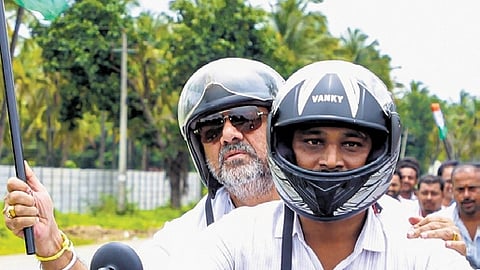 DyCM DK Shivakumar rides pillion during the Congress’ Janandolana programme in Maddur on Monday  
