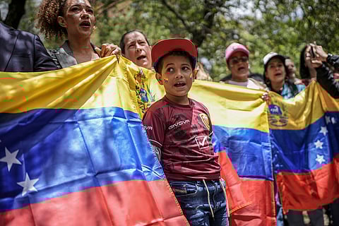Demonstrators hold a Venezuelan flag outside that nation's consulate to protest the contested presidential election results in Bogota, Colombia.
