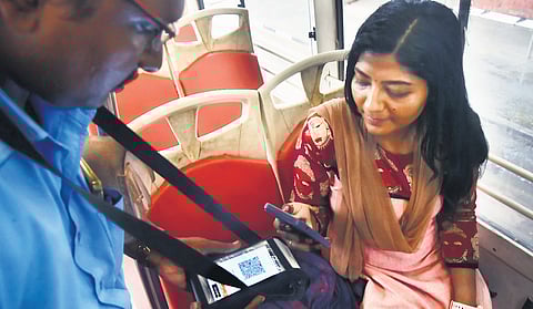 A passenger scanning QR code to pay the ticket amount on an MTC bus 