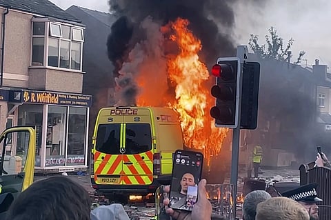 A police van buns as and unruly crowd clashed with police, Tuesday, July 30, 2024, in Southport, northwest England, near where three girls were stabbed to death in a dance class the day before.