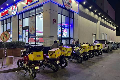 Motorcycles of delivery workers are parked outside an air-conditioned bus station in northern Riyadh on July 27, 2024. Workers in Arab states face some of the highest exposure to heat stress in the world.