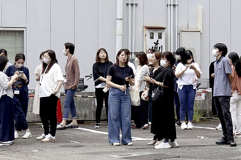 People take shelter outside building following an earthquake in Miyazaki, western Japan, Thursday, Aug. 8, 2024.
