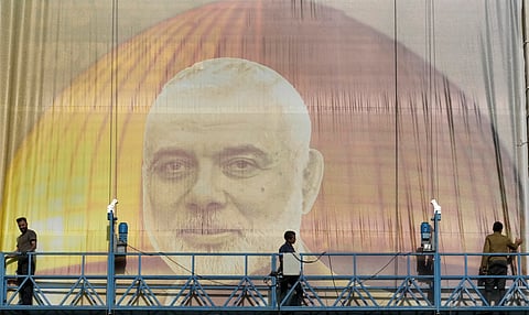 Iranian workers install a huge banner on a wall showing a portrait of Hamas leader Ismail Haniyeh and the Dome of Rock Mosque at the Al-Aqsa Mosque compound of Jerusalem at Felestin (Palestine) Sq. in Tehran, Iran, Wednesday, July 31, 2024.