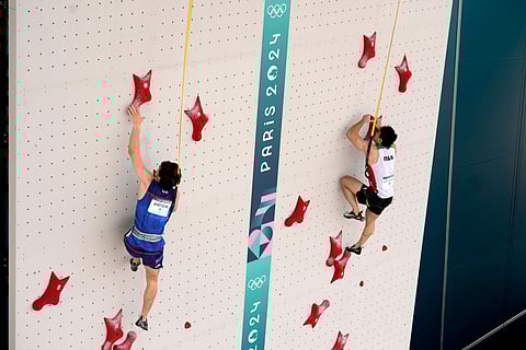 Sam Watson of the United States, left, and Reza Alipour Shenazandifard of Iran compete in the men's speed final during the sport climbing competition at the 2024 Summer Olympics.