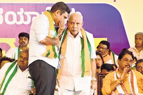 BJP state president BY Vijayendra has a word with his father and former CM BS Yediyurappa at the Mysuru Chalo Padayatra valedictory in Mysuru on Saturday, as Union minister HD Kumaraswamy and LoP R Ashoka look on.