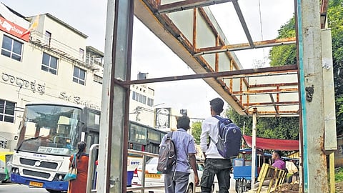 Commuters wait to board a bus at a rundown bus stop opposite Sri Radhakrishna theatre on CIL Road in RT Nagar on Sunday 