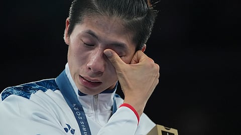 Gold medalist Taiwan's Lin Yu-ting wipes tears during a medals ceremony for the women's 57 kg final boxing match at the 2024 Summer Olympics.