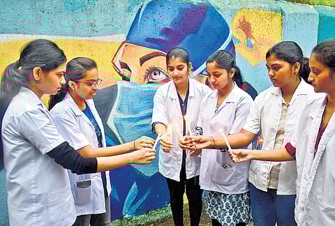 Students and doctors take part in a candle light protest in Mumbai on Monday.