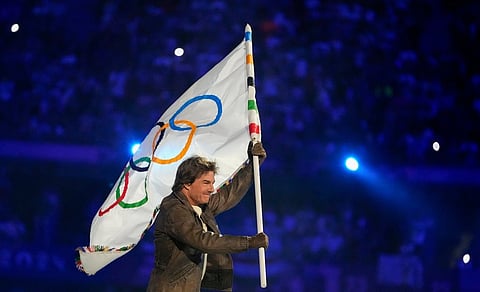 Tom Cruise carries the Olympic flag during the 2024 Summer Olympics closing ceremony at the Stade de France, Sunday, Aug. 11, 2024, in Saint-Denis, France. 