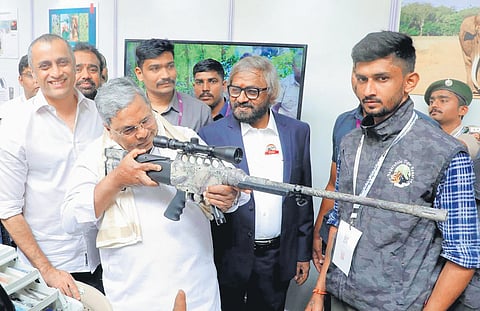 Karnataka CM Siddaramaiah checks out an exhibit at the inauguration of the International conference on man-elephant conflict management, at GKVK Campus in Bengaluru on Monday. Forest Minister Eshwar Khandre and others look on.