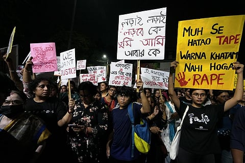 People holding placards while protesting the brutal rape and murder of a trainee doctor in a state-run hospital in Kolkata.