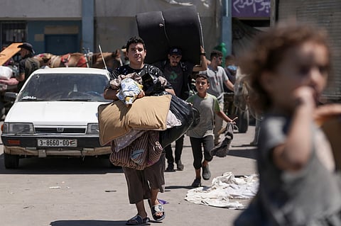 Palestinians evacuate a school that had been their shelter, in eastern Deir al-Balah, Gaza Strip, Friday, Aug. 16, 2024, after the Israeli military dropped leaflets asking civilians to evacuate