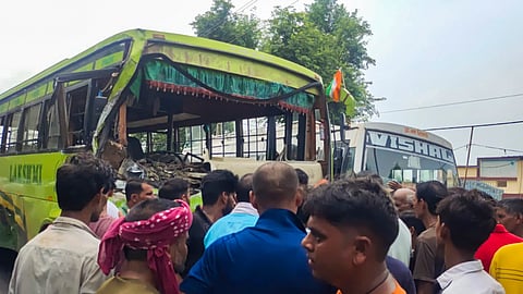 Locals gather after a collision between a pickup van and a bus, in Bulandshahr, Sunday, Aug. 18, 2024.