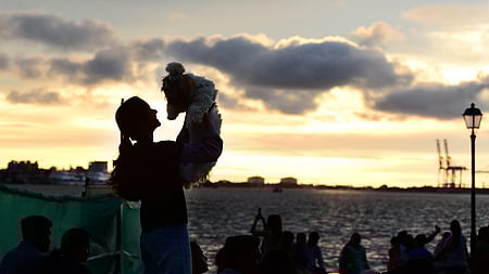 A youngster enjoys magic hour in the evening with her pet dog Izabu Shitzu at the lakeside of Rajendra Maidan in Kochi on Sunday.