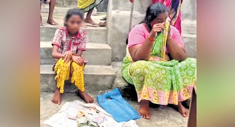 11-year-old girl, Meera Durga, begs for money from the public for funeral expenses of her mother in Nirmal district on Sunday