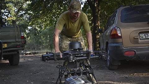 A soldier of Ukraine's 141st separate infantry brigade loads a drone with a parcel for soldiers on a mission at the frontline in Zaporizhzhia region, Ukraine, Monday, Aug 19, 2024. 