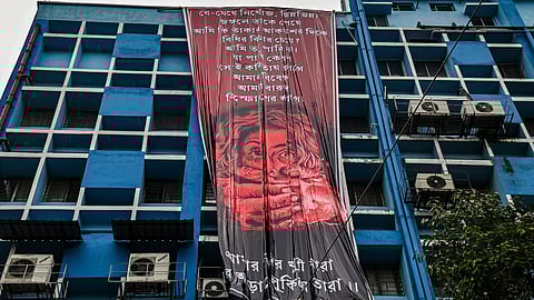 Junior doctors hang a giant poster from the roof of the R G Kar College and Hospital during their protest against alleged rape and murder of a woman trainee doctor of the hospital, in Kolkata.