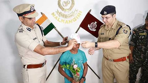 Minor Chhattisgarh Maoist Suryam surrendering before SWR DIG Charan Singh Meena and Superintendent of Police Nitesh Wadhwani at district police headquarters in Malkangiri