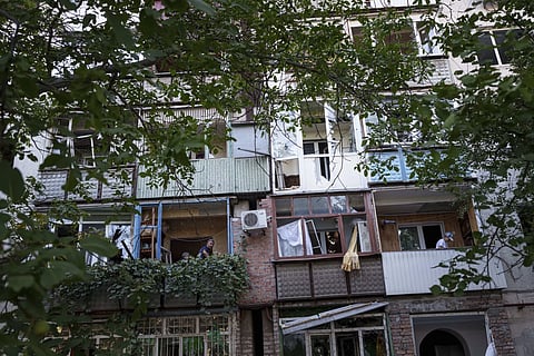 Local residents clear broken glass from their balconies after Russian bombardment of a residential neighbourhood in Pokrovsk, Donetsk region, Ukraine, Tuesday, Aug 20, 2024.