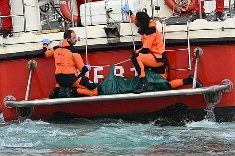 Divers of the Vigili del Fuoco, the Italian Corps. of Firefighters arrive with a body bag at the back of the boat in Porticello near Palermo, on August 21, 2024 two days after the British-flagged luxury yacht Bayesian sank.