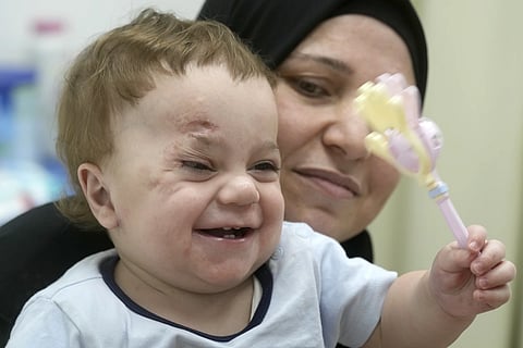 Ten-month-old Palestinian infant Mostafa Qadoura, who has already lost his eye and his immediate family to the horrors of Israel's war against Hamas in Gaza, plays with his grandmother Amna Abd Rabou, at the New Administrative Capital Hospital, just outside Cairo, Egypt on Aug 14, 2024.