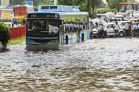  A bus moves through a waterlogged road as vehicles get stuck in a traffic jam after heavy rainfall, in New Delhi, Friday, Aug. 23, 2024.