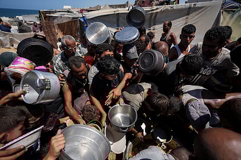 Displaced Palestinians at a food distribution center in Deir al Balah, central Gaza Strip.