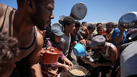 Displaced Palestinians gather for food distribution in Deir al Balah, central Gaza Strip.