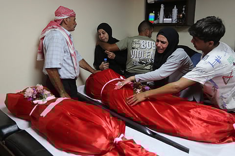 Syrian citizens mourn over the dead bodies of their loved ones killed by an Israeli airstrike in Wadi al-Kfour, Nabatieh province, south Lebanon, Saturday, Aug. 17, 2024.