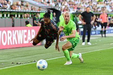 Bayern's Michael Olise, left, in action against Wolfsburg's Jakub Kaminski during the Bundesliga match between VfL Wolfsburg and FC Bayern Munich at the Volkswagen Arena in Wolfsburg, Germany.